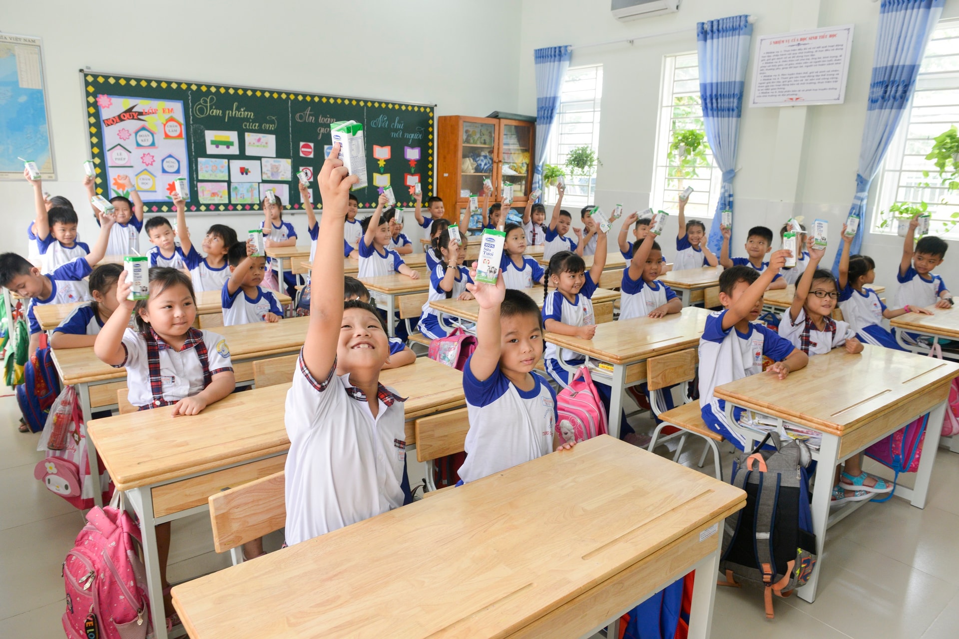 Các em học sinh trường Tiểu học Trang Tấn Khương, xã Long Thới, huyện Nhà Bè vui vẻ đón nhận những hộp sữa an toàn từ chương trình SHĐ.