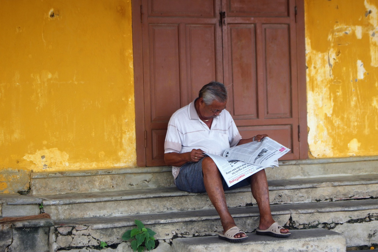 Một số người dân phố cổ Hội An bình thản ngồi đọc báo.