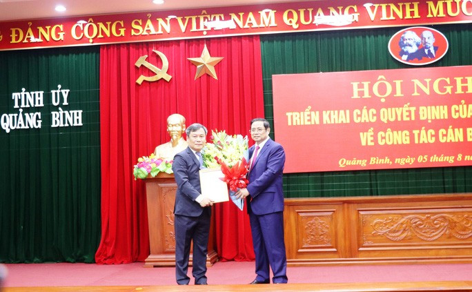 Ông Phạm Minh Chính - Trưởng Ban Tổ chức Trung ương trao quyết định, tặng hoa cho tân Bí thư Tỉnh ủy Quảng Bình Vũ Đại Thắng (trái)