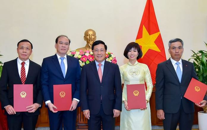 Ủy viên Bộ Chính trị, Phó Thủ tướng, Bộ trưởng Bộ Ngoại giao Phạm Bình Minh trao quyết định và chúc mừng các cán bộ được bổ nhiệm chức vụ mới.