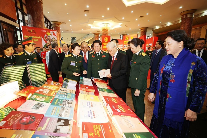 Tổng Bí thư, Chủ tịch nước, Bí thư Quân ủy Trung ương Nguyễn Phú Trọng và các đại biểu xem các ấn phẩm quốc phòng. (Ảnh: Trí Dũng/TTXVN)