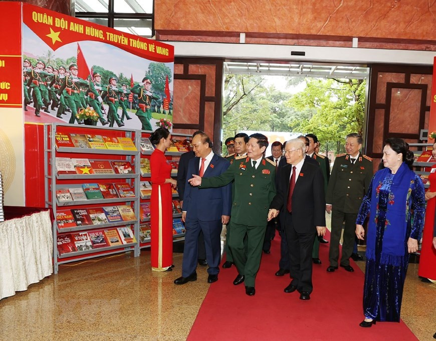 Tổng Bí thư, Chủ tịch nước, Bí thư Quân ủy Trung ương Nguyễn Phú Trọng và các đại biểu tham quan khu trưng bày các ấn phẩm quốc phòng. (Ảnh: Trí Dũng/TTXVN)