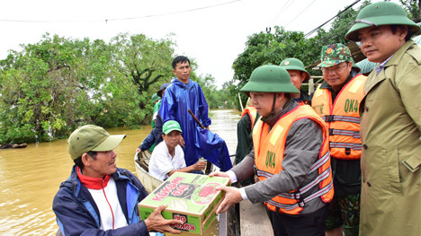 Chủ tịch UBND huyện Phong Điền Nguyễn Văn Bình (đứng, đội mũ cối) cùng Chủ tịch UBND tỉnh Thừa Thiên - Huế kiểm tra tình hình lũ lụt ngày 10/10.