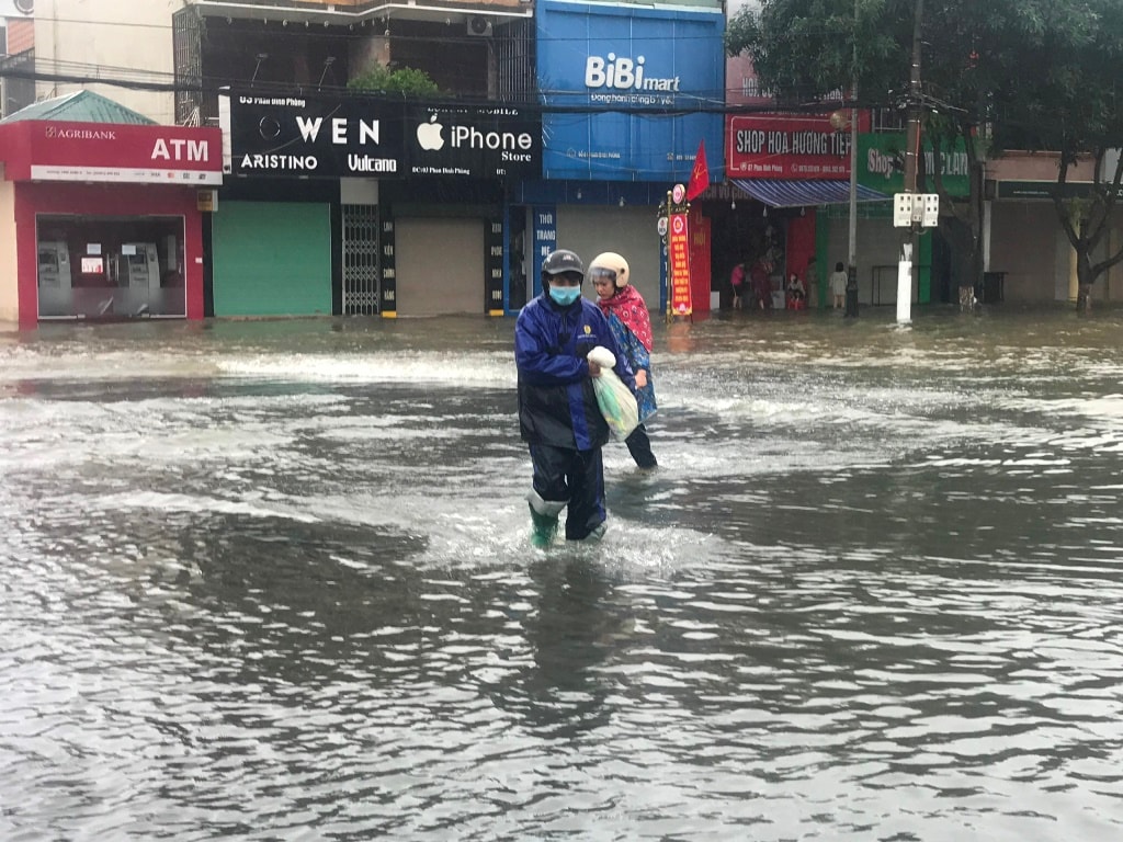 Người đàn ông ở TP Hà Tĩnh lội nước lũ đi mua gạo về tiếp tế cho gia đình.