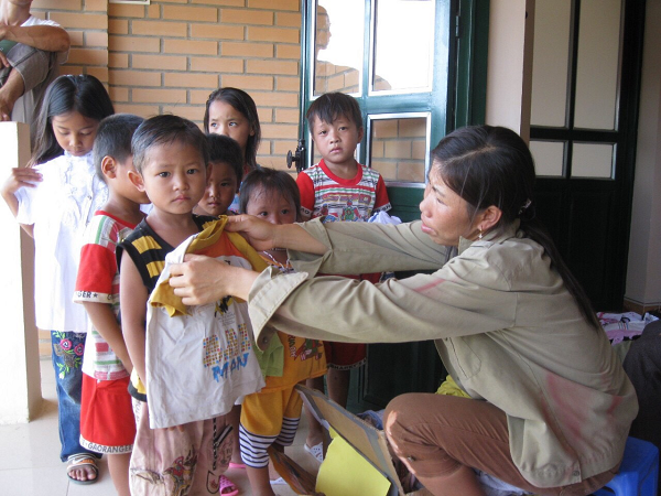 Chị Lò Thị Tím trao cho các con những tấm áo do các nhà hảo tâm ủng hộ. (Ảnh do Ban Thi đua - Khen thưởng Trung ương cung cấp).
