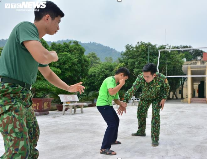 Thượng úy Nguyễn Huy Tiến dạy Tẩn Minh Khải bài võ thể dục của bộ đội biên phòng. (Ảnh: Quốc Việt).