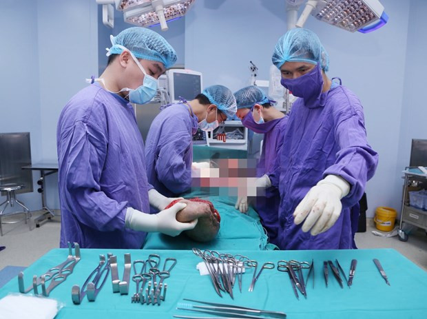 Các bác sỹ tiến hành phẫu thuật cắt bỏ khối u. (Ảnh: PV/Vietnam+).