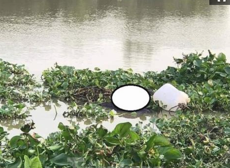 Thi thể nạn nhân được phát hiện trên sông Thị Tính. Ảnh: Tiền Phong