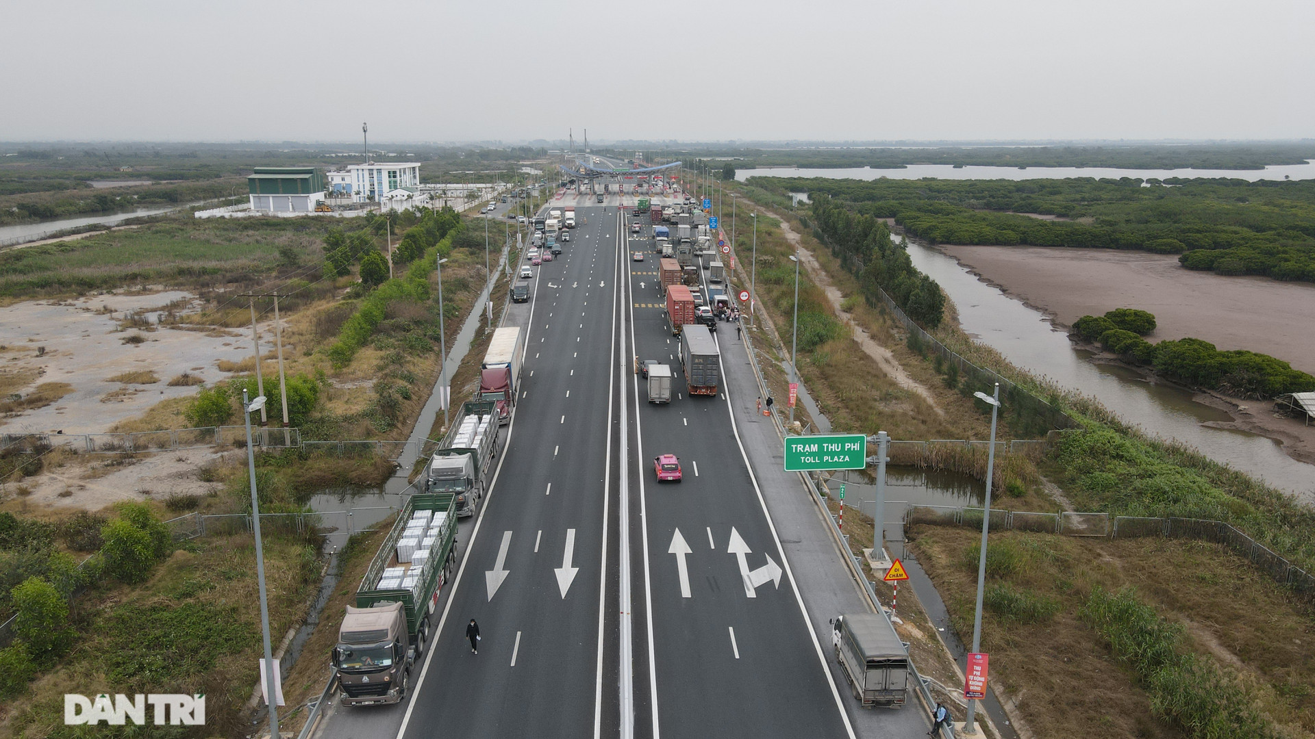 Hình ảnh hàng dài xe tải chở hàng, nối đuôi nhau chờ khai báo y tế trên cao tốc khi qua trạm thu phí đầu cầu Bạch Đằng.