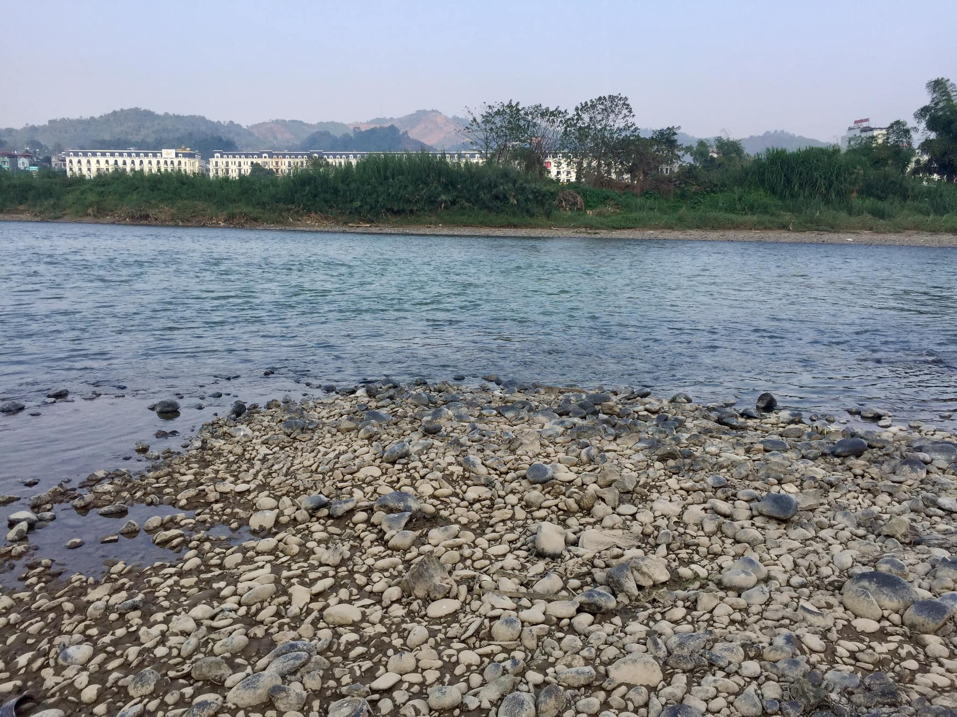Thích thú với dòng sông nước trong xanh nhưng do đang ảnh hưởng của dịch bệnh Covid-19 và sợ không an toàn nên người dân thành phố Lào Cai không ai dám xuống những bãi đá lộ thiên dưới lòng sông Hồng để vui chơi.
