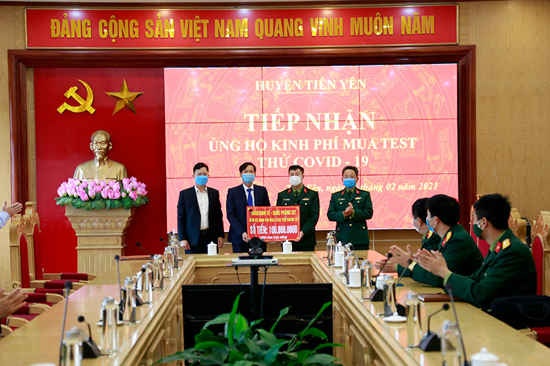 Đại diện Đoàn Kinh tế - Quốc phòng 327 trao tiền hỗ trợ cho lãnh đạo huyện Tiên Yên.