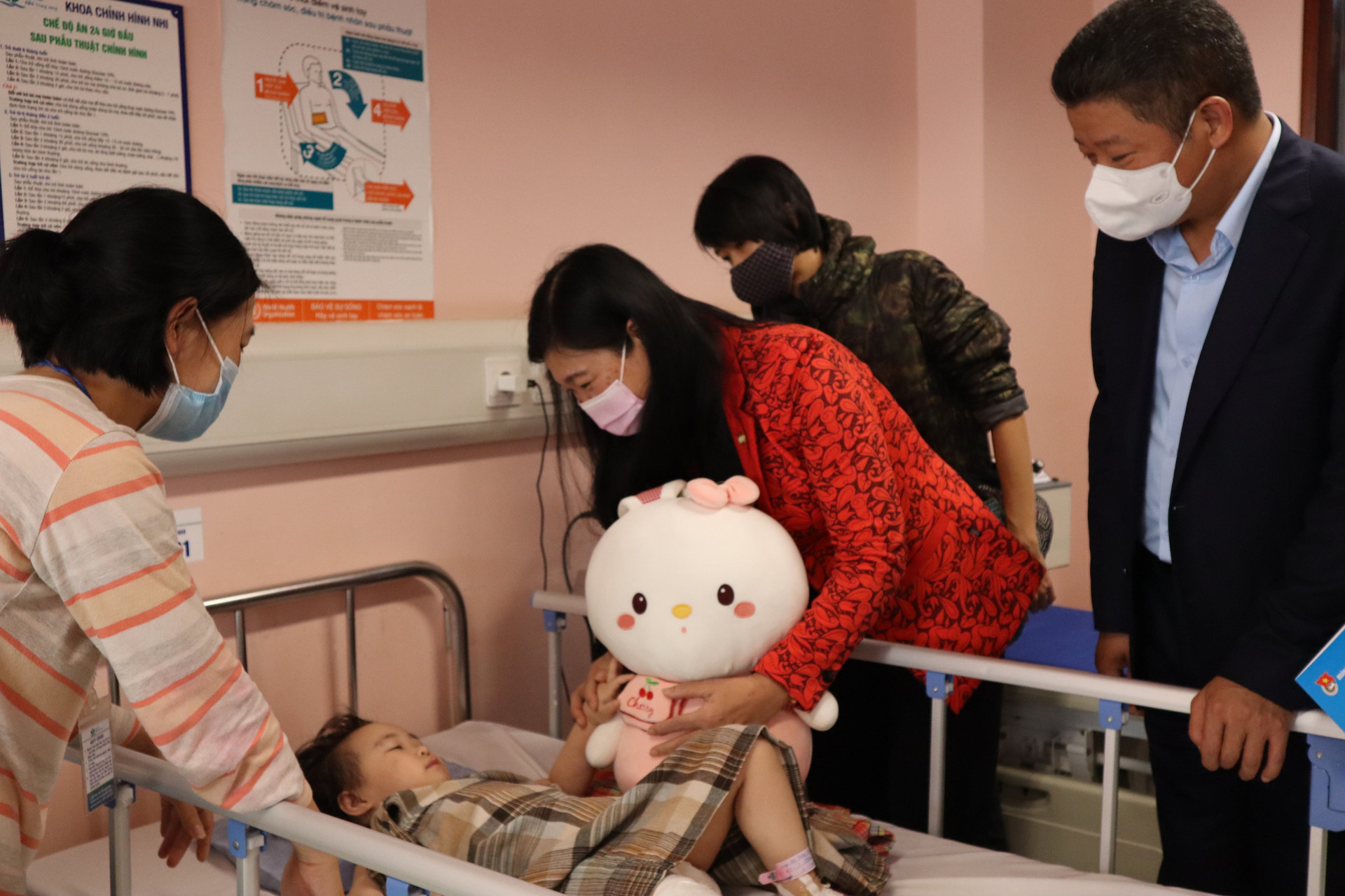 Chủ tịch UBMTTQ thành phố Hà Nội thăm hỏi sức khỏe bệnh nhi và chia vui cùng gia đình cháu bé.  