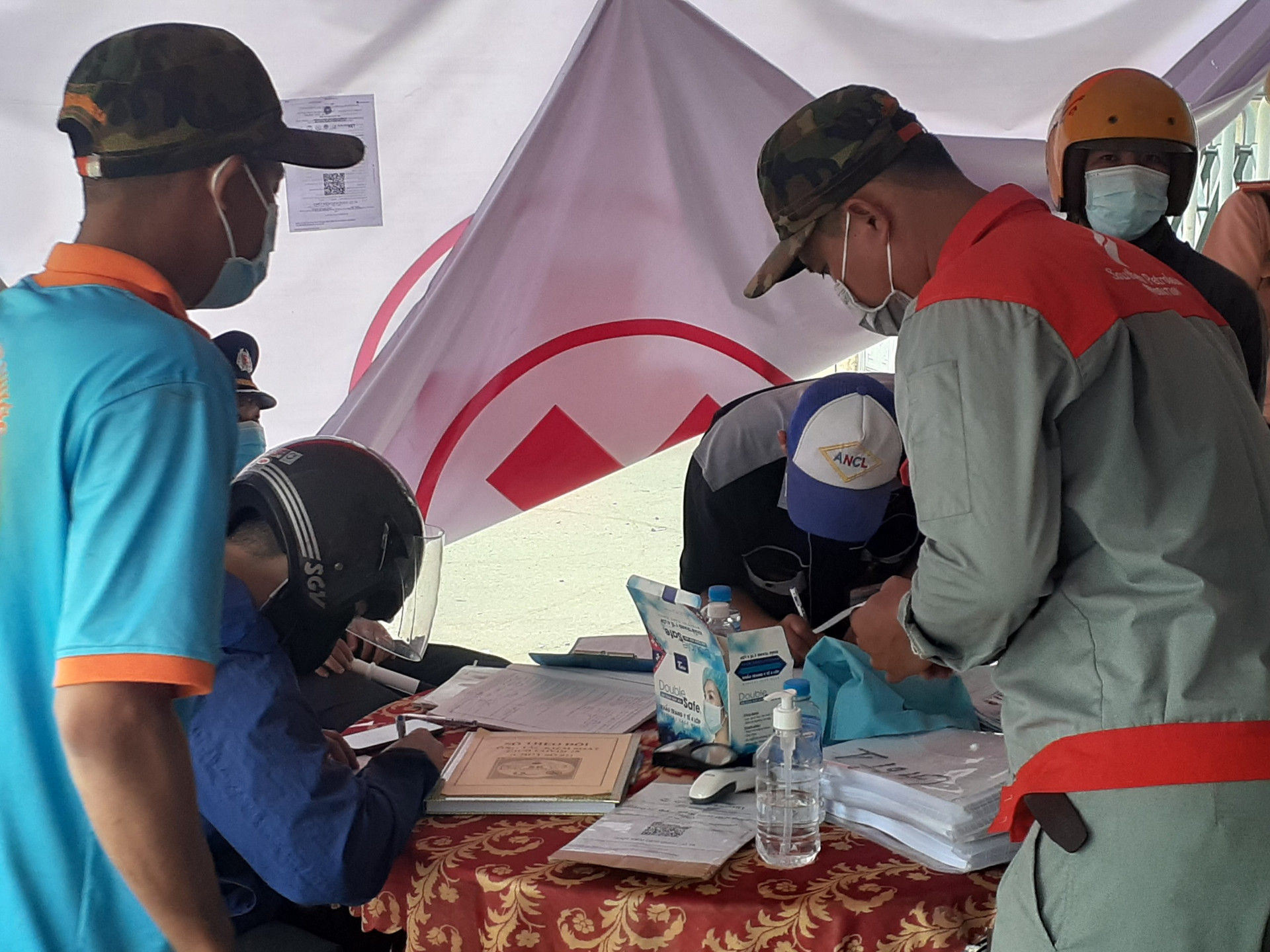 Người lao động từ TP Hồ Chí Minh khai báo y tế tại chốt kiểm soát dịch bệnh gần cầu Hóa An (Đồng Nai).