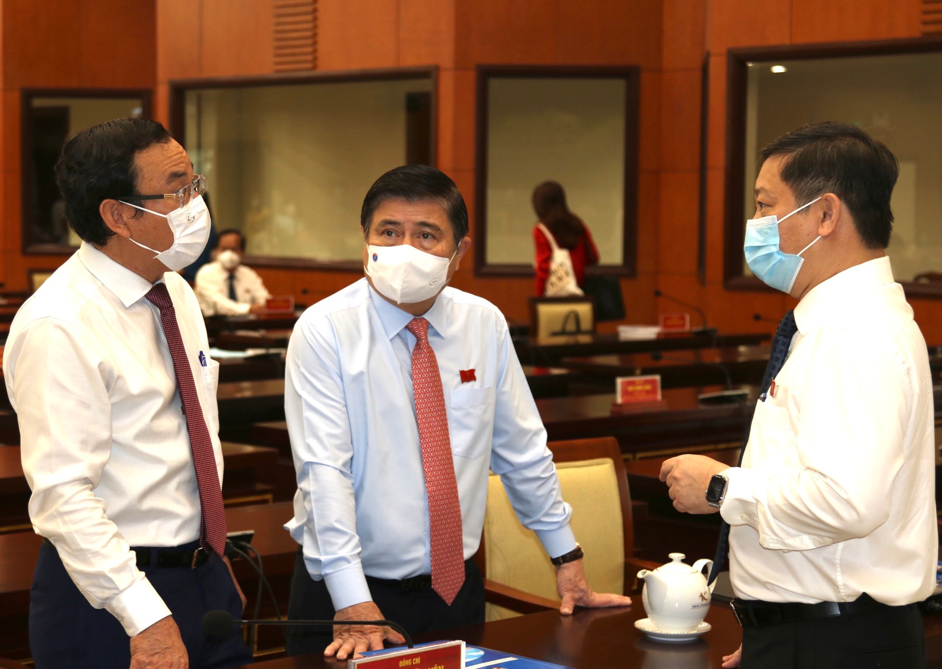 Bí thư Thành ủy TP HCM Nguyễn Văn Nên (tay trái) trao đổi với các lãnh đạo thành phố bên lề kỳ họp. (Ảnh: HMC).