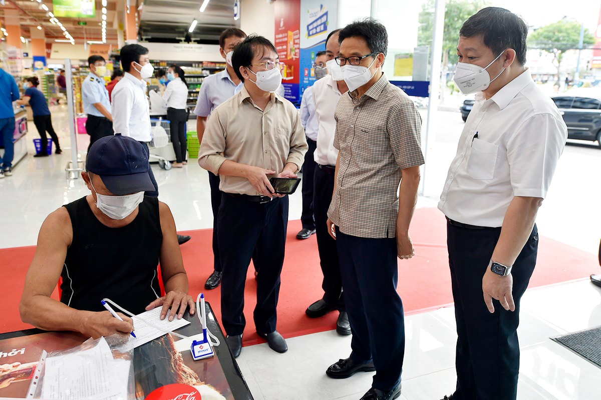 Đại diện lãnh đạo siêu thị Coop mart báo cáo với Phó Thủ tướng Vũ Đức Đam về công tác phòng chống dịch bệnh tại siêu thị.