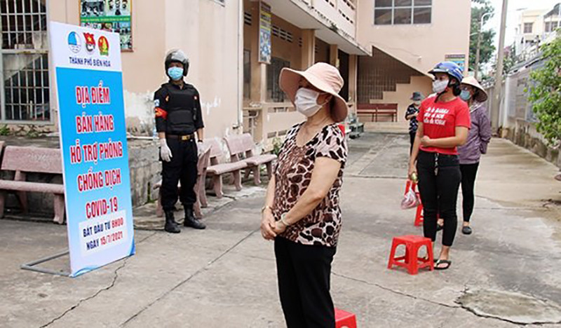 Người dân tuân thủ xếp hàng giãn cách tại điểm bán hàng ở Trường THCS Lê Lợi TP.Biên Hòa. Ảnh H.Q.