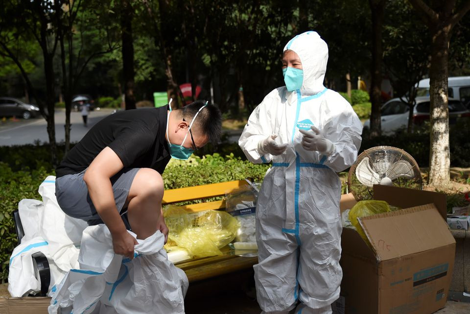 Nhân viên y tế đang mặc đồ bảo hộ trong một điểm xét nghiệm Covid-19 sau hàng loạt ca nhiễm do biến thể Delta ở Vũ Hán, Trung Quốc (Ảnh: Reuters)