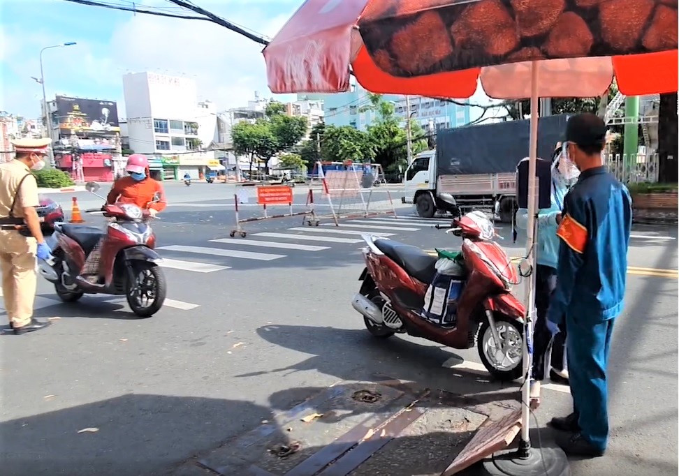 Người dân được hướng dẫn quét QR tự động tại chốt kiểm dịch trên đường Cách Mạng Tháng 8 (quận 3).