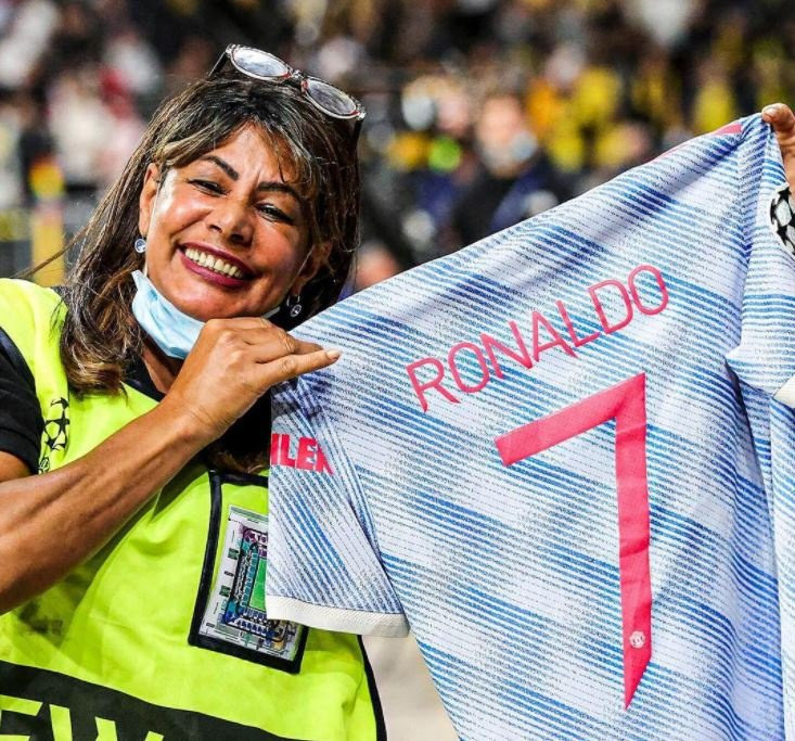 Nữ nhân viên vui vẻ khoe áo đấu được Ronaldo tặng sau trận.