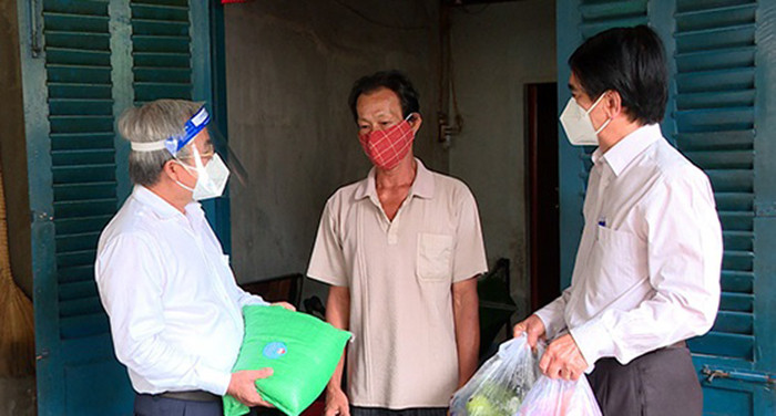Chủ tịch Ủy ban MTTQ Việt Nam tỉnh Cao Văn Quang (bên trái) trao quà cho người dân phường An Bình, TP Biên Hòa. Ảnh: CTV.