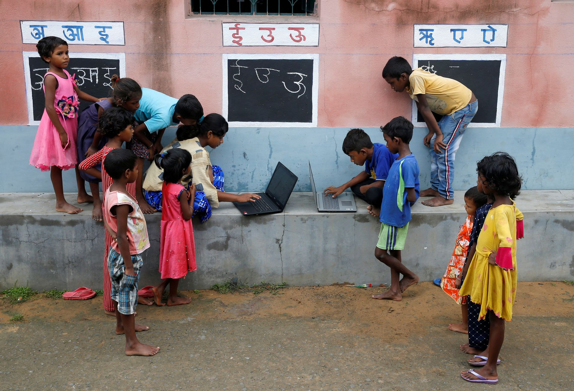 Những đứa trẻ tập trung vào những chiếc máy tính ít ỏi của lớp học “đường phố” còn nhiều thiếu thốn. Ảnh Reuters