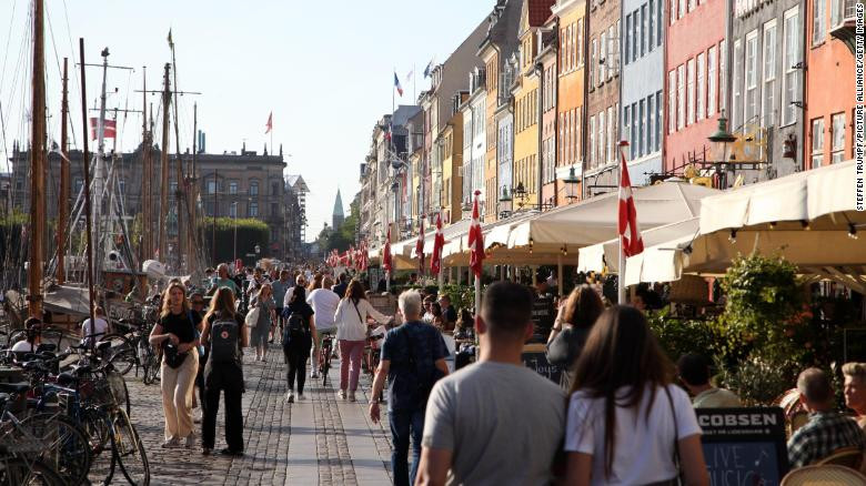 Người dân đi dạo dọc Nyhavn, một bến cảng nổi tiếng với du khách, nằm ở thủ đô Copenhagen của Đan Mạch (3/9/2021). Ảnh CNN