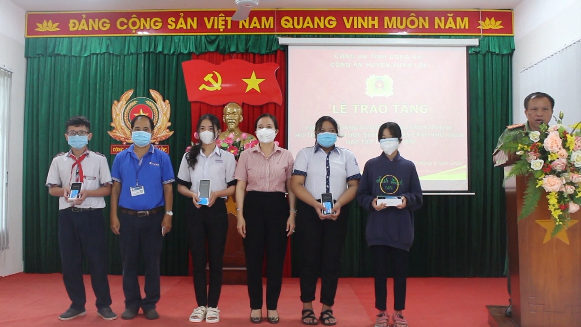 Chủ tịch UBND huyện Xuân Lộc Nguyễn Thị Cát Tiên (áo hồng, ở giữa) trao tặng thiết bị học tập cho các em học sinh nghèo. 