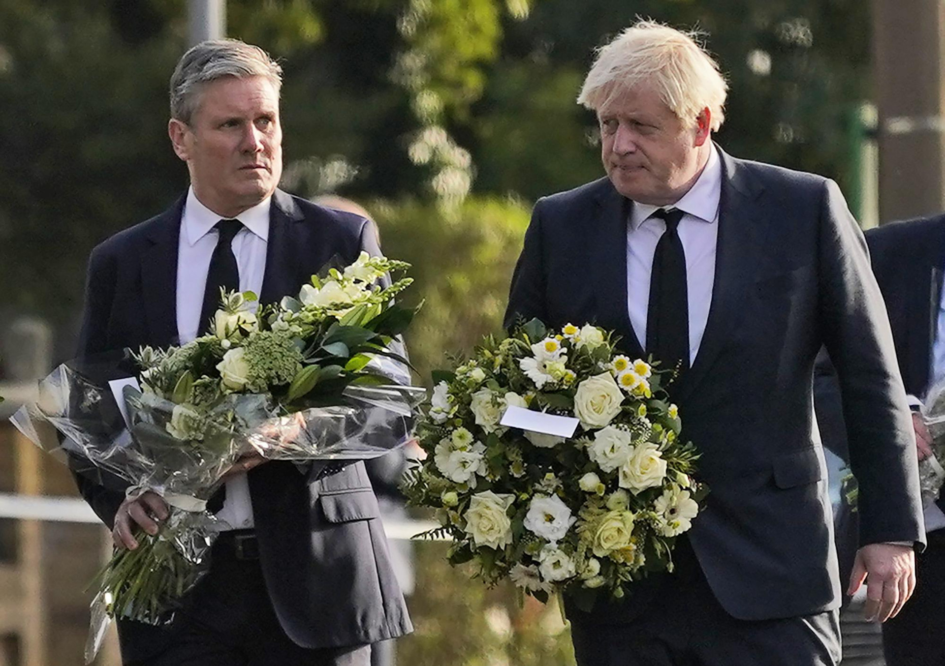 Thủ tướng Anh Boris Johnson (phía bên phải) và Lãnh đạo Đảng Lao động Keir Starmer đến đặt hoa viếng tại nơi một thành viên Quốc hội bị đâm hôm 15/10 ở thị trấn Leigh-on-Sea, hạt Essex, Anh. Ảnh: AP/Alberto Pezzali.