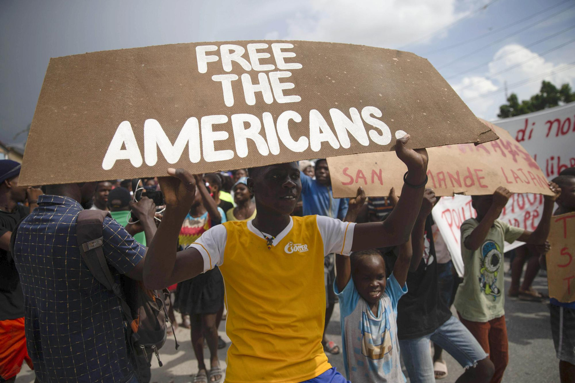 Những người dân biểu tình yêu cầu trả tự do cho các nhà truyền giáo bị bắt cóc gần trụ sở của các nhà truyền giáo ở làng Titanyen, phía bắc thủ đô Port-au-Prince, Haiti. Ảnh: AP/Joseph Odelyn.