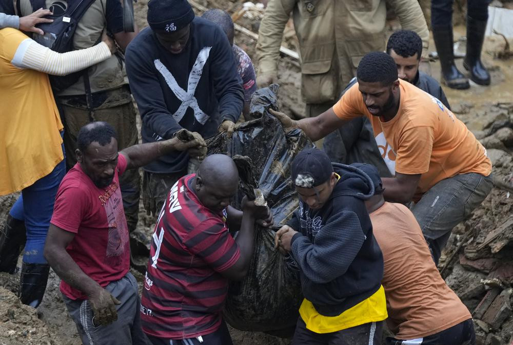 Người dân và tình nguyện viên dọn thi thể một nạn nhân thiệt mạng do lở đất ở Petropolis, Brazil. Ảnh: AP.