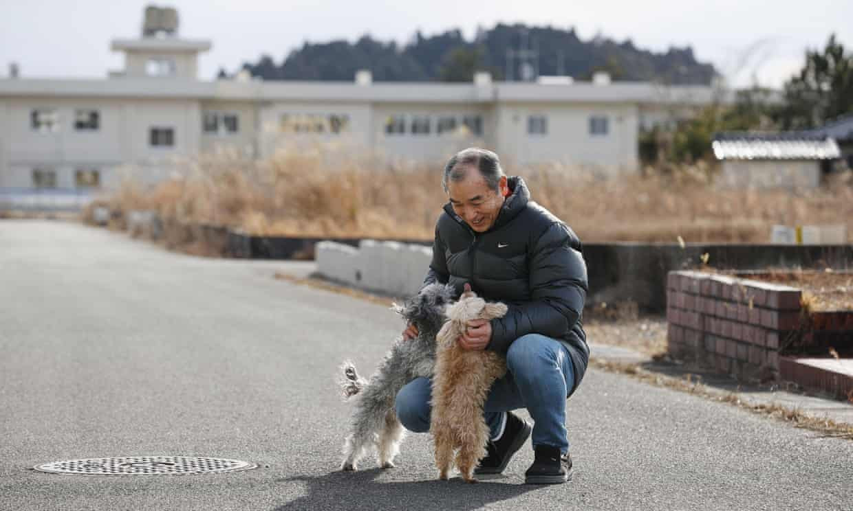 Ông Yoichi Yatsuda chơi với những chú chó của mình ở thị trấn Futaba, Nhật Bản. Ảnh: Kota Endo / AP.