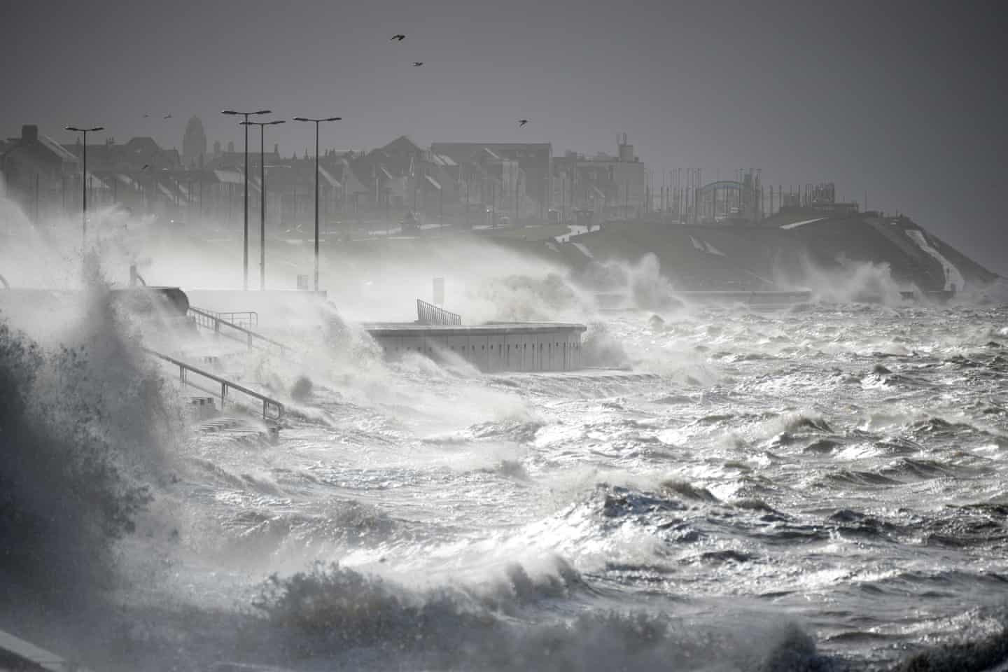Sóng bão đánh sập lối đi dạo gần biển. Ảnh: Christopher Furlong / Getty Images.