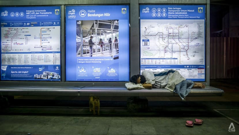 Một người phụ nữ vô gia cư ngủ ở trạm xe buýt tại trung tâm thành phố Jakarta. Ảnh: CNA.