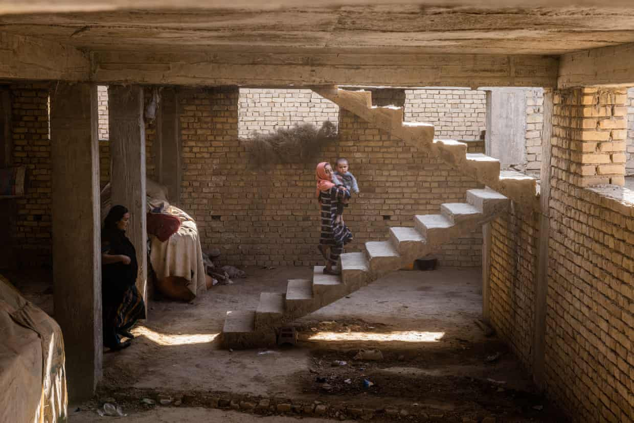 Laalah bế em trai của mình, Faakhir, trong ngôi nhà tạm của họ ở tỉnh Balkh. Ảnh: The Guardian.