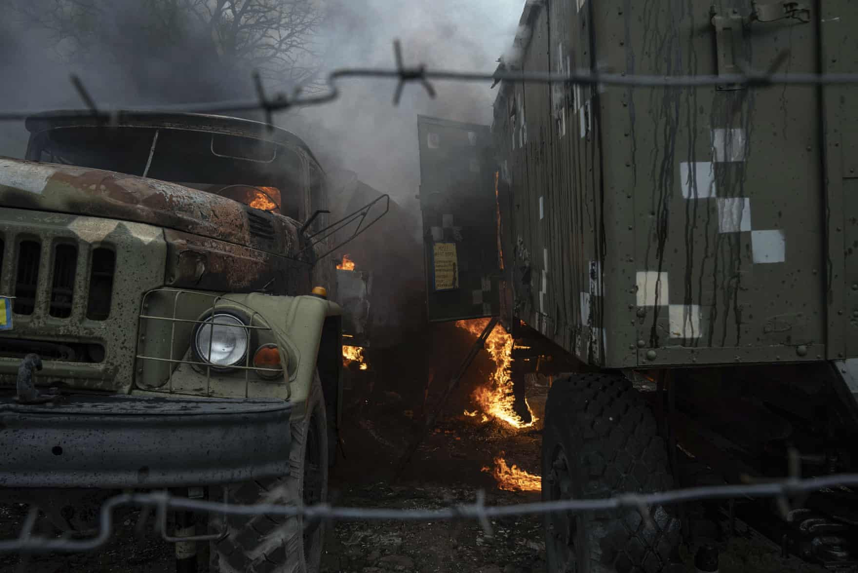 Xe tải quân sự bốc cháy tại một căn cứ phòng không sau cuộc tấn công của Nga tại thành phố Mariupol, Ukraine. Ảnh: The Guardian.
