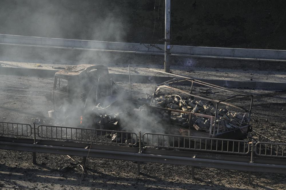 Mảnh vỡ của chiếc xe quân sự đang bốc cháy trên đường phố ở thủ đô Kiev sau một cuộc giao tranh ngày 26/2. Ảnh: AP.