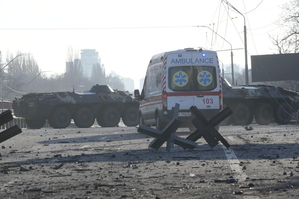 Xe cứu thương đỗ gần xe bọc thép của Ukraine trên con phố ở thủ đô Kiev ngày 26/2. Ảnh: AP.