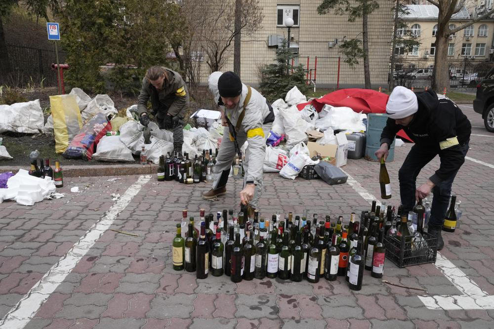 Lực lượng dân phòng chuẩn bị cocktail Molotov trong một sân ở thủ đô Kiev, Ukraine ngày 27/2. Ảnh: AP.