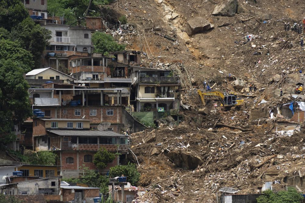 Những ngôi nhà phía sườn đồi bị tàn phá nghiêm trọng sau trận sạt lở. Ảnh: AP.