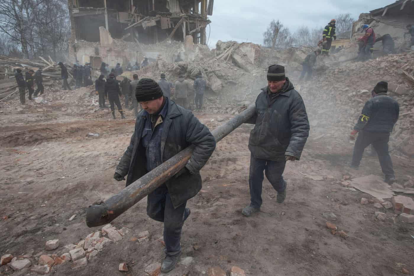 Người dân dọn dẹp các mảnh vỡ tại khu vực đặt căn cứ quân sự ở thành phố Okhtyrka, Ukraine. Ảnh: Cơ quan Báo chí của Lực lượng Mặt đất Ukraine / Reuters.