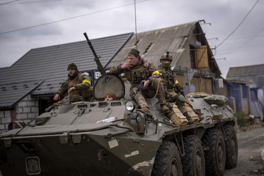 Những người lính Ukraine trên một chiếc xe quân sự bọc thép ở ngoại ô thủ đô Kiev, Ukraine. Ảnh: AP.