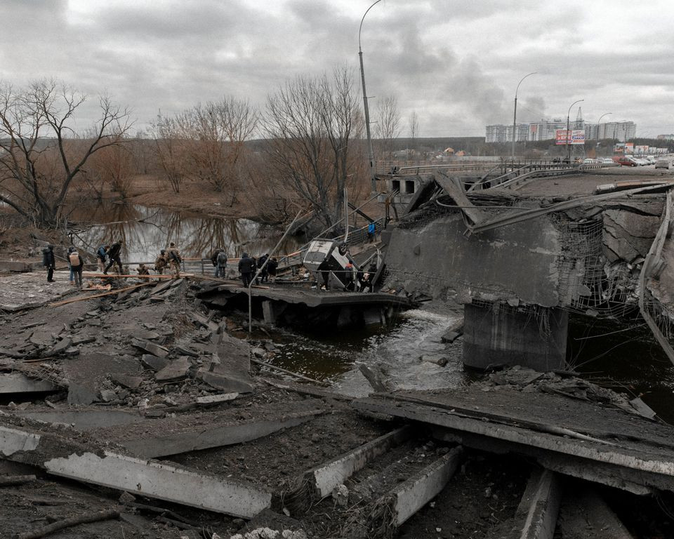 Người dân Ukraine băng qua một cây cầu tại sông Irpin ở ngoại ô thủ đô Kiev, Ukraine. Ảnh: AP.