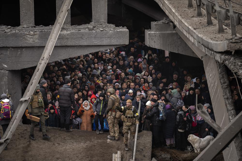 Người dân Ukraine tập trung dưới một cây cầu khi đang chạy trốn qua sông Irpin ở ngoại ô thủ đô Kiev, Ukraine. Ảnh: AP.