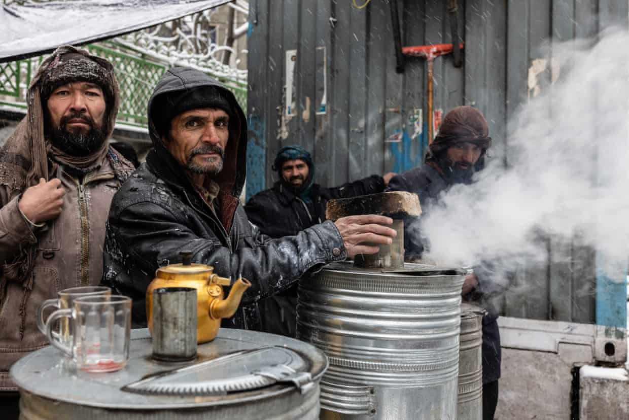 Những người bán trà sưởi ấm bàn tay trong một ngày lạnh giá ở Kabul. Ảnh: The Guardian.