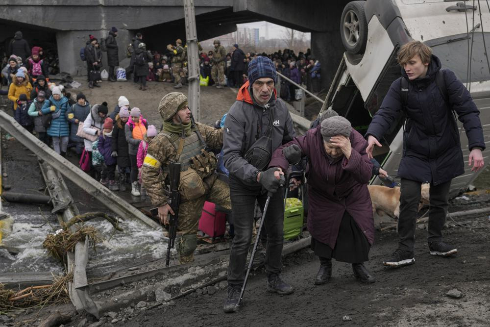 Người dân Ukraine băng qua một cây cầu tại sông Irpin ở ngoại ô thủ đô Kiev, Ukraine. Ảnh: AP.