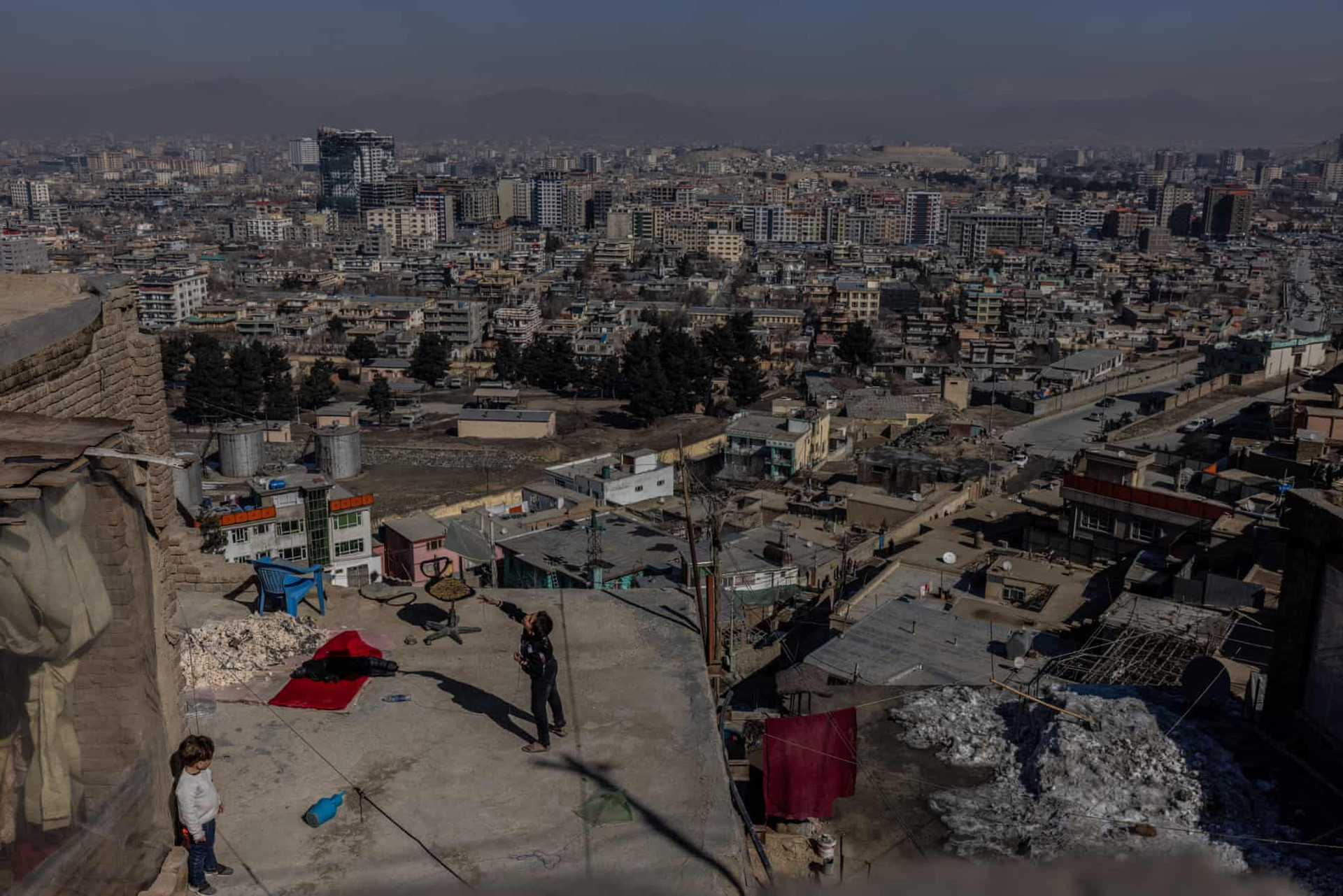 Một cậu bé thả diều từ sân thượng ở thủ đô Kabul. Ảnh: The Guardian.