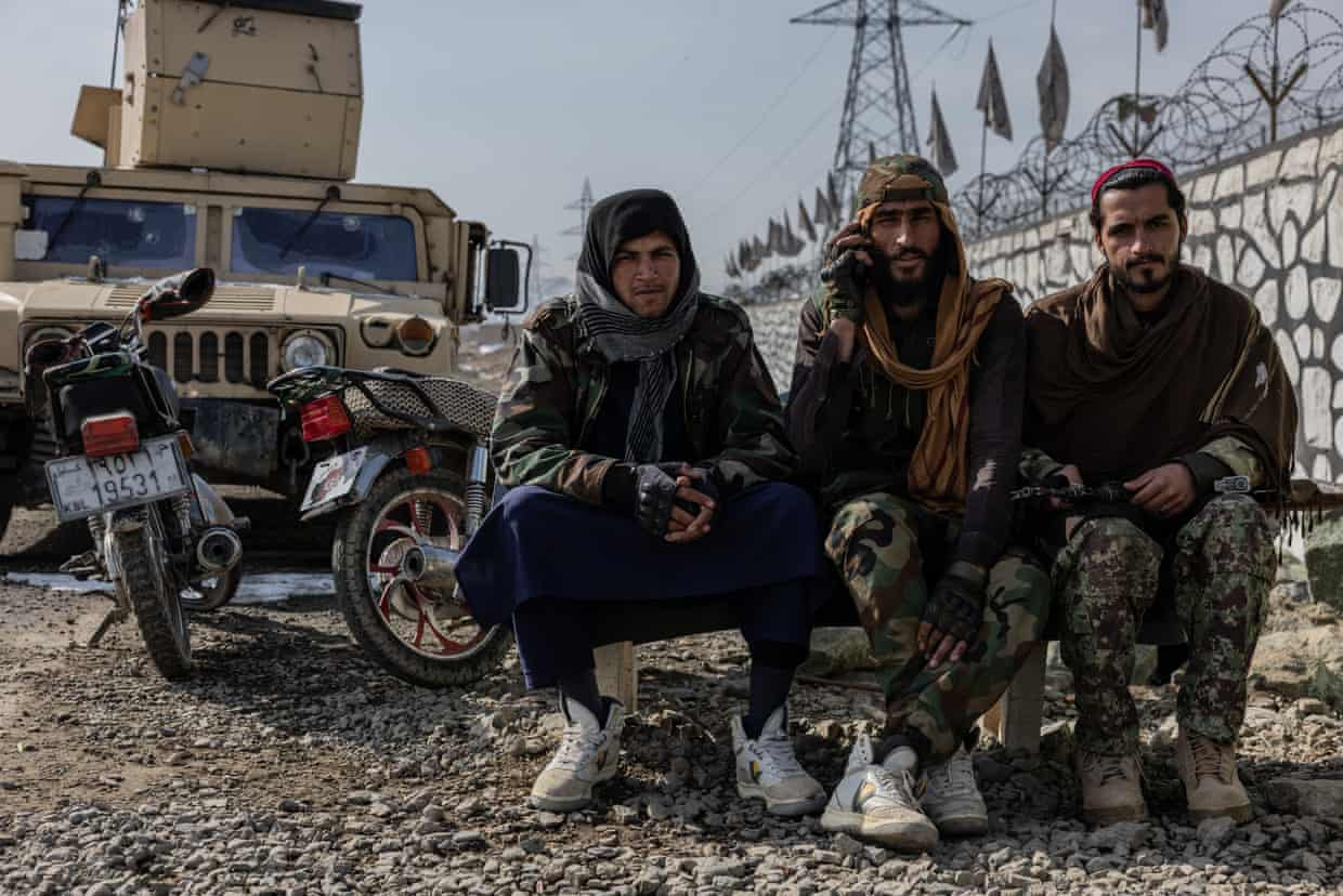 Các chiến binh Taliban ngồi bên vệ đường ở quận Mohammad Agha của Logar. Ảnh: The Guardian.