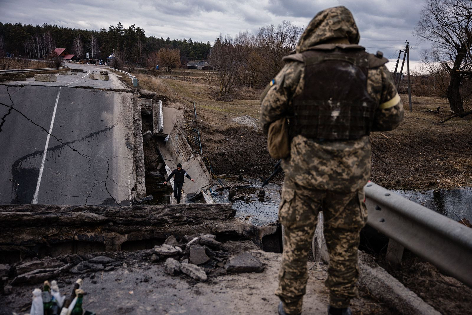 Binh sĩ Ukraine quan sát người dân đi qua cầu ở một ngôi làng phía đông thị trấn Brovary, Ukraine. Ảnh: CNN.