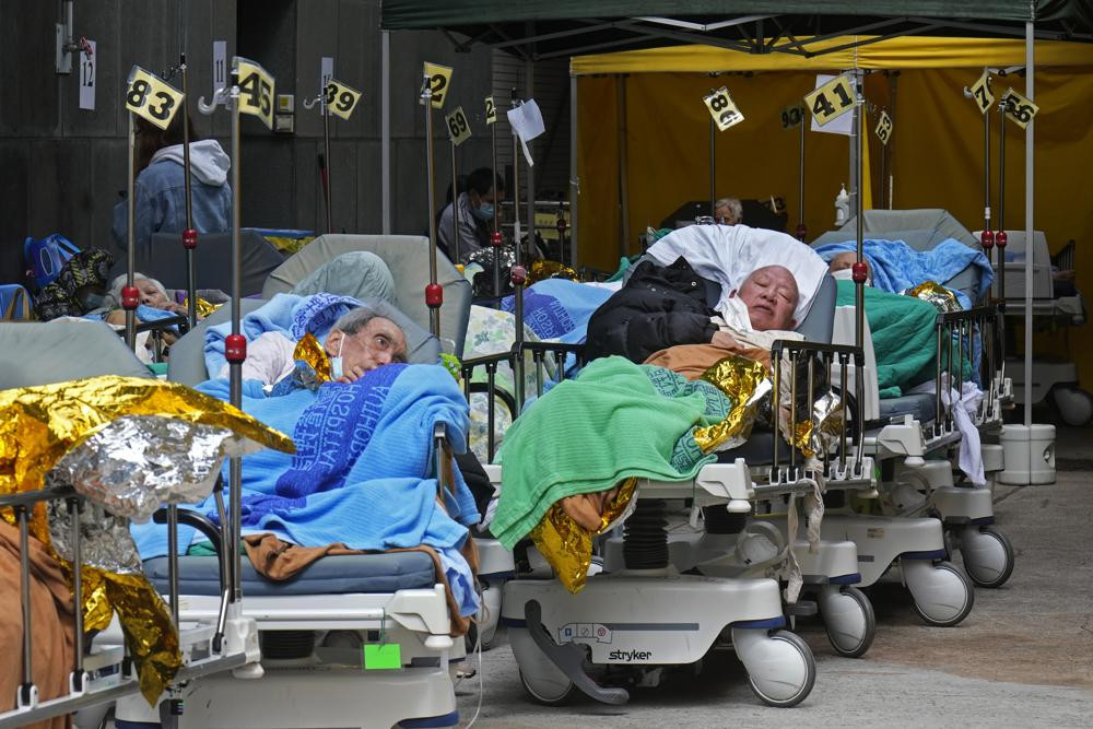 Các bệnh nhân nằm trên giường bệnh chờ đợi tại một khu vực tạm thời phía bên ngoài Trung tâm Y tế Caritas ở Hong Kong. Ảnh: AP.