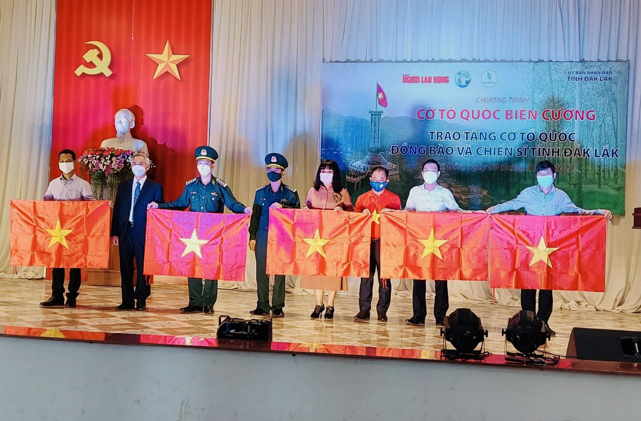 Đại diện Lãnh đạo UBND tỉnh Đắk Lắk và Báo Người Lao Động trao cờ tặng các đơn vị địa phương.